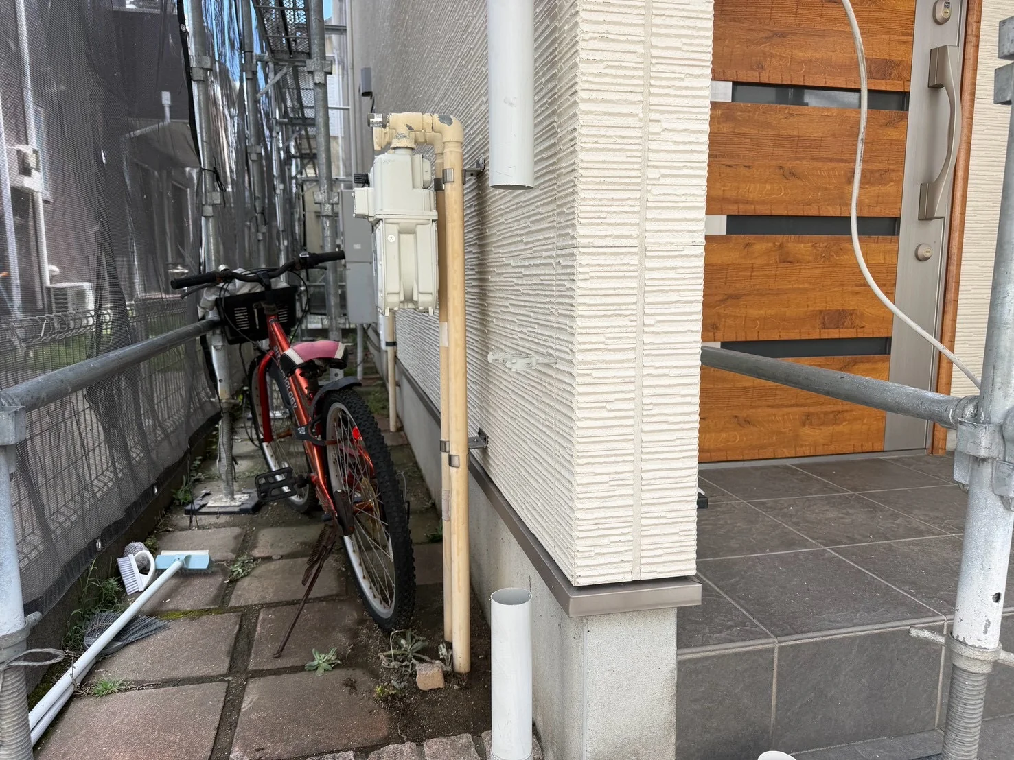 玄関前の竪樋を新しい部材でつなぎ直す前の作業状況