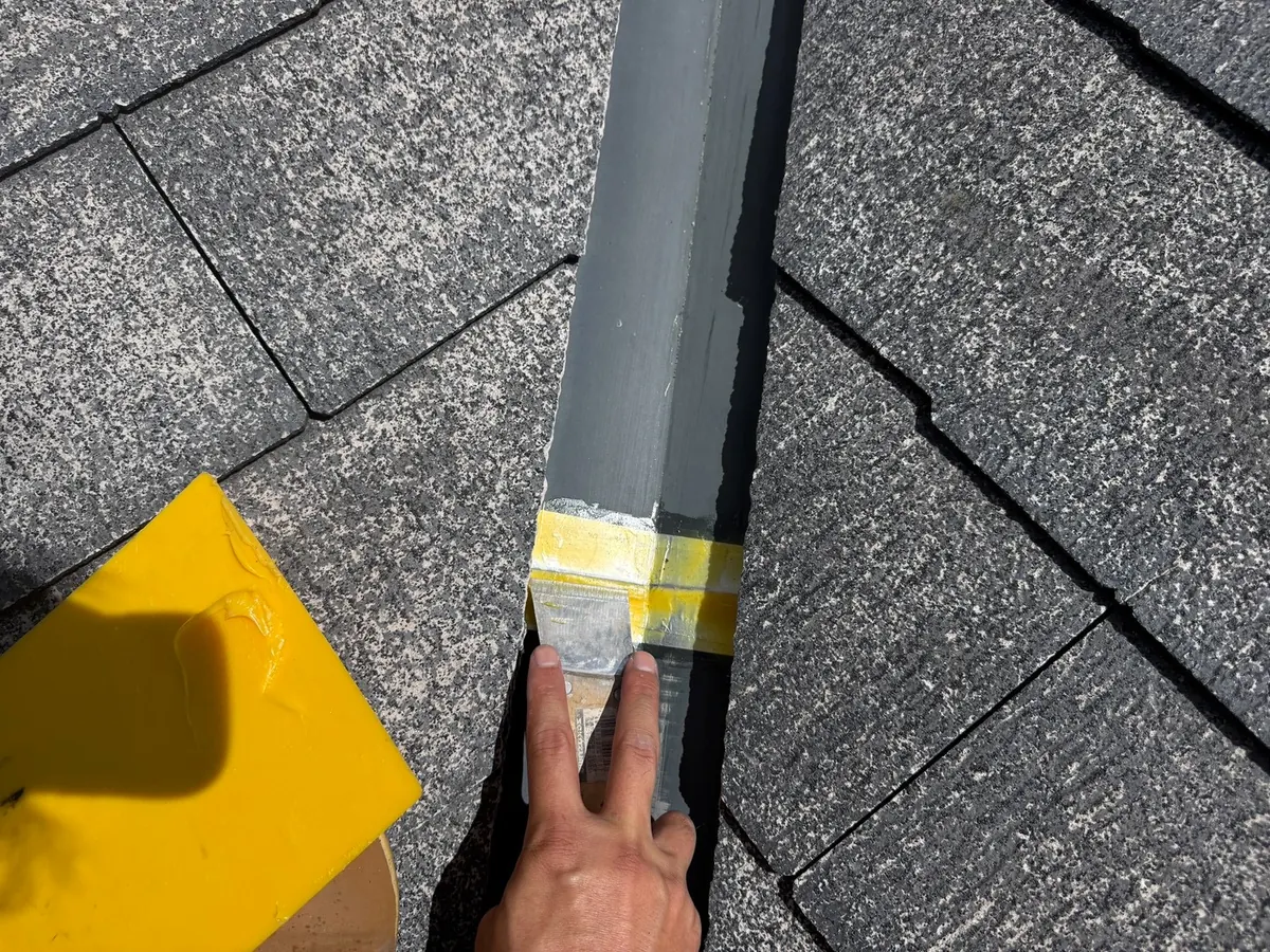 谷板金のずれたジョイント部分へ防水テープと補強パテを施工している様子