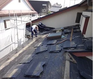 松戸市K様邸の葺き替え工事で既存のスレート屋根材を撤去している実写真
